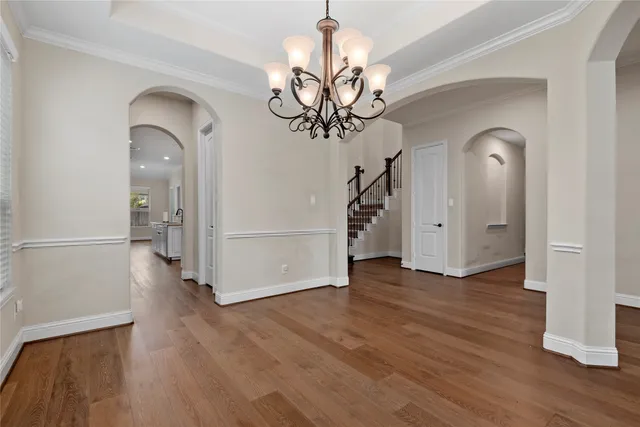 a kitchen with stainless steel appliances kitchen island granite countertop a stove a sink and white cabinets with wooden floor