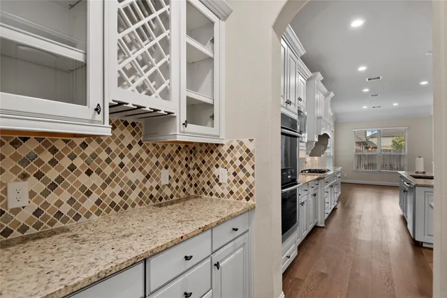a view of an empty room with wooden floor and a fireplace