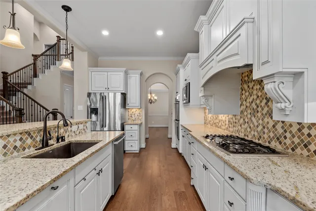 a bathroom with a granite countertop sink a mirror a shower and a toilet