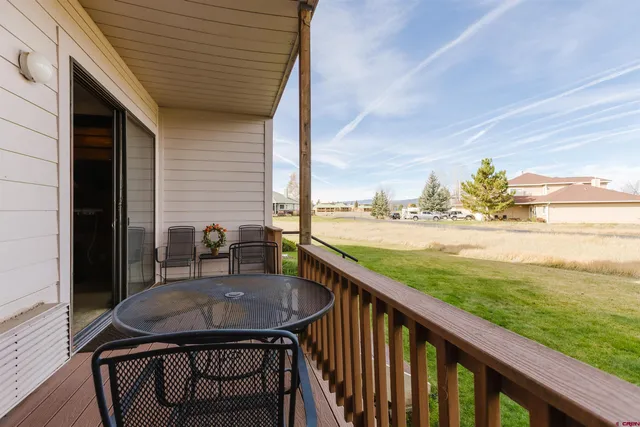 a view of a balcony with table and chairs and wooden fence