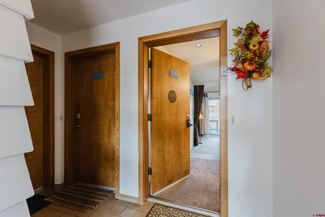 a view of a hallway with wooden floor and a potted plant