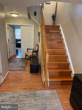 a view of a livingroom with wooden floor and stairs
