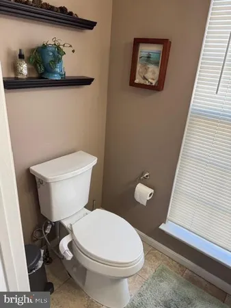 a white toilet sitting next to a bathroom sink and vanity