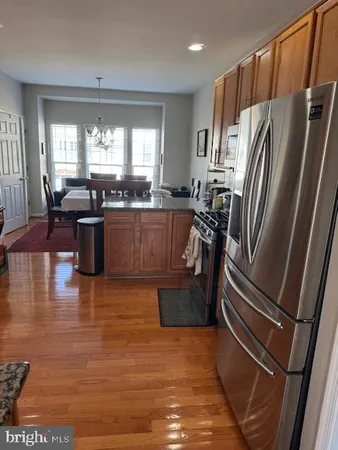 a kitchen with stainless steel appliances granite countertop a refrigerator a sink a stove and island