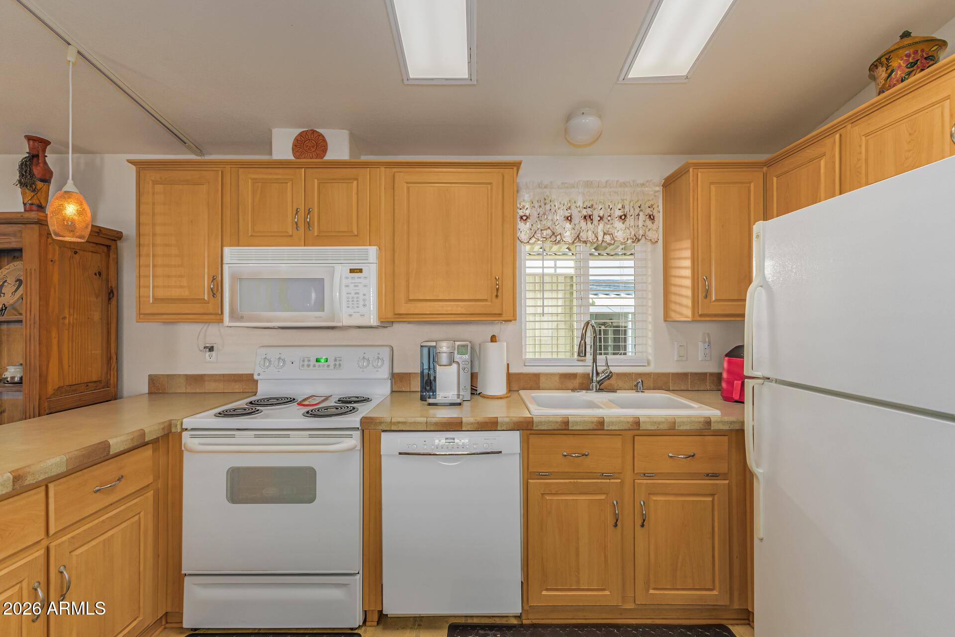 9302 East Broadway Road, Unit 186 Mesa, AZ 85208 - Photo 19 of 40 a kitchen with cabinets appliances a sink and a window