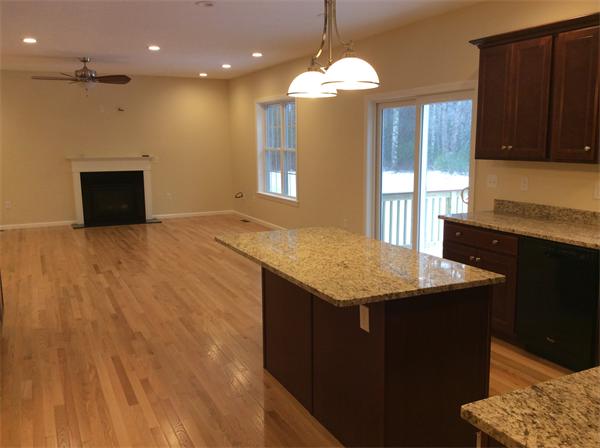 Lot 20-61 Forbes Road Rochester, MA 02770 - Photo 3 of 7 a kitchen with stainless steel appliances granite countertop a sink a microwave oven and a dining table with wooden floor