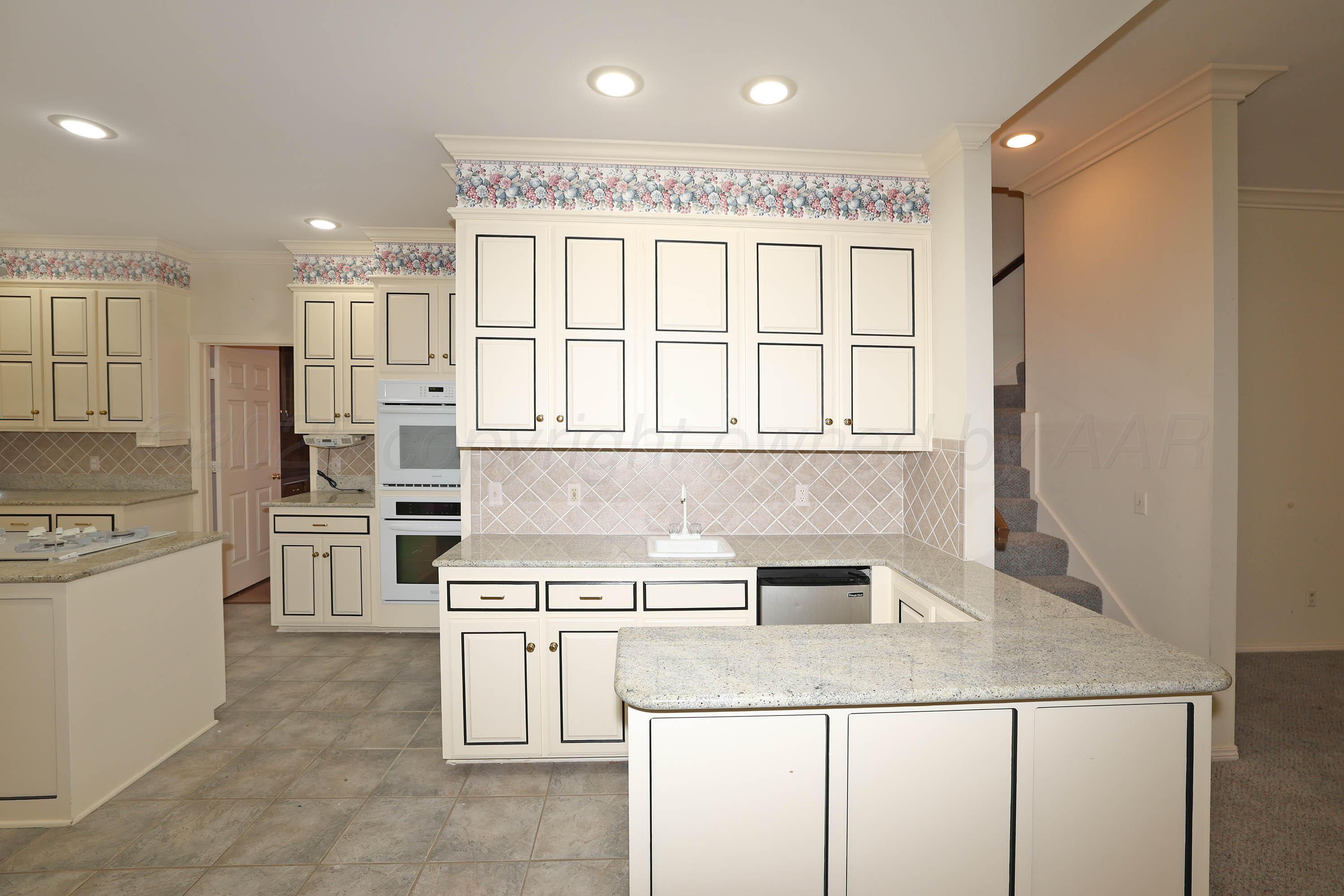 7707 Bent Tree Drive Amarillo, TX 79121 - Photo 12 of 47 a kitchen with stainless steel appliances granite countertop a stove and a refrigerator