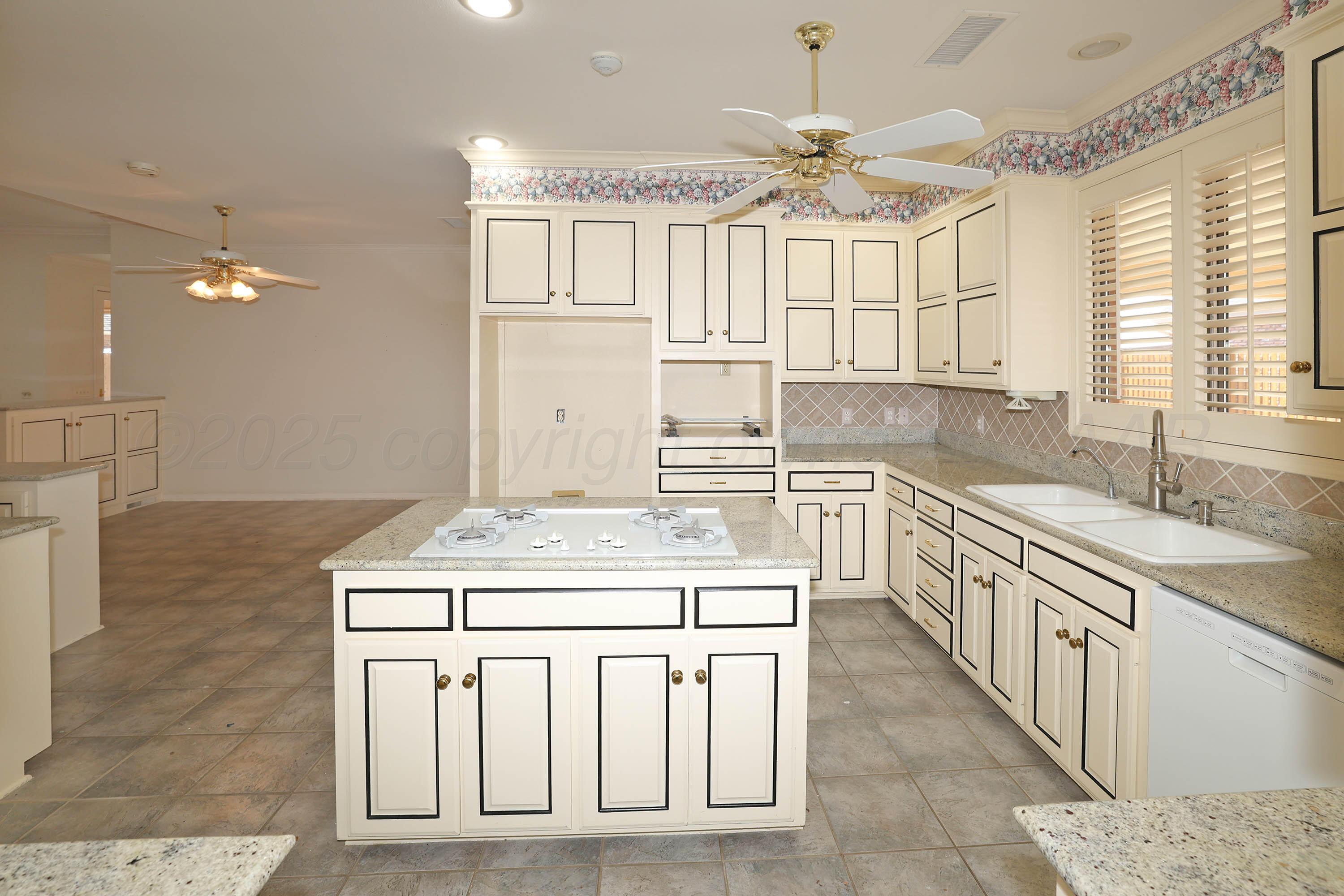 7707 Bent Tree Drive Amarillo, TX 79121 - Photo 14 of 47 a kitchen with a sink stove and cabinets
