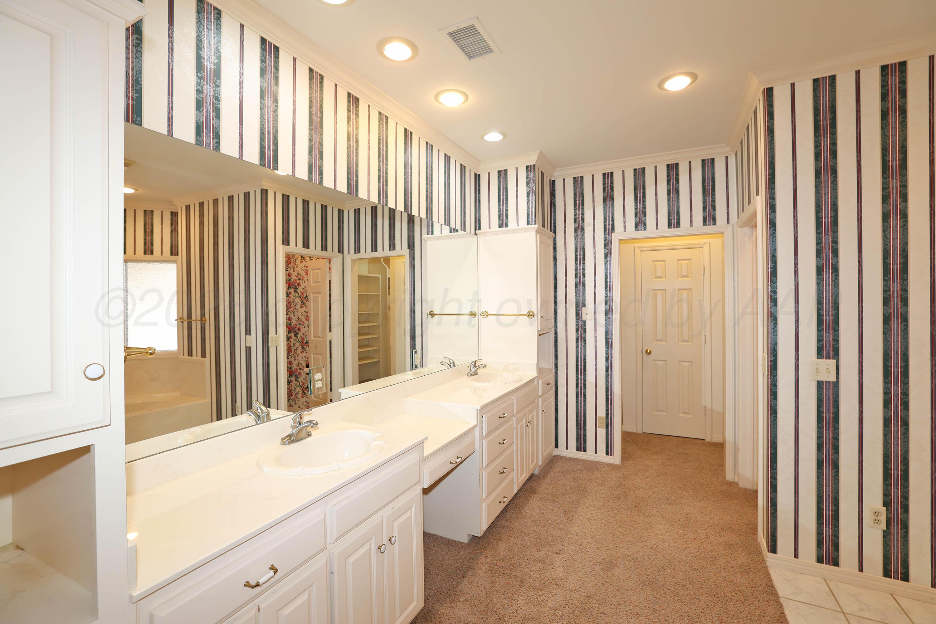7707 Bent Tree Drive Amarillo, TX 79121 - Photo 21 of 47 a bathroom with a double vanity sink and a bathtub