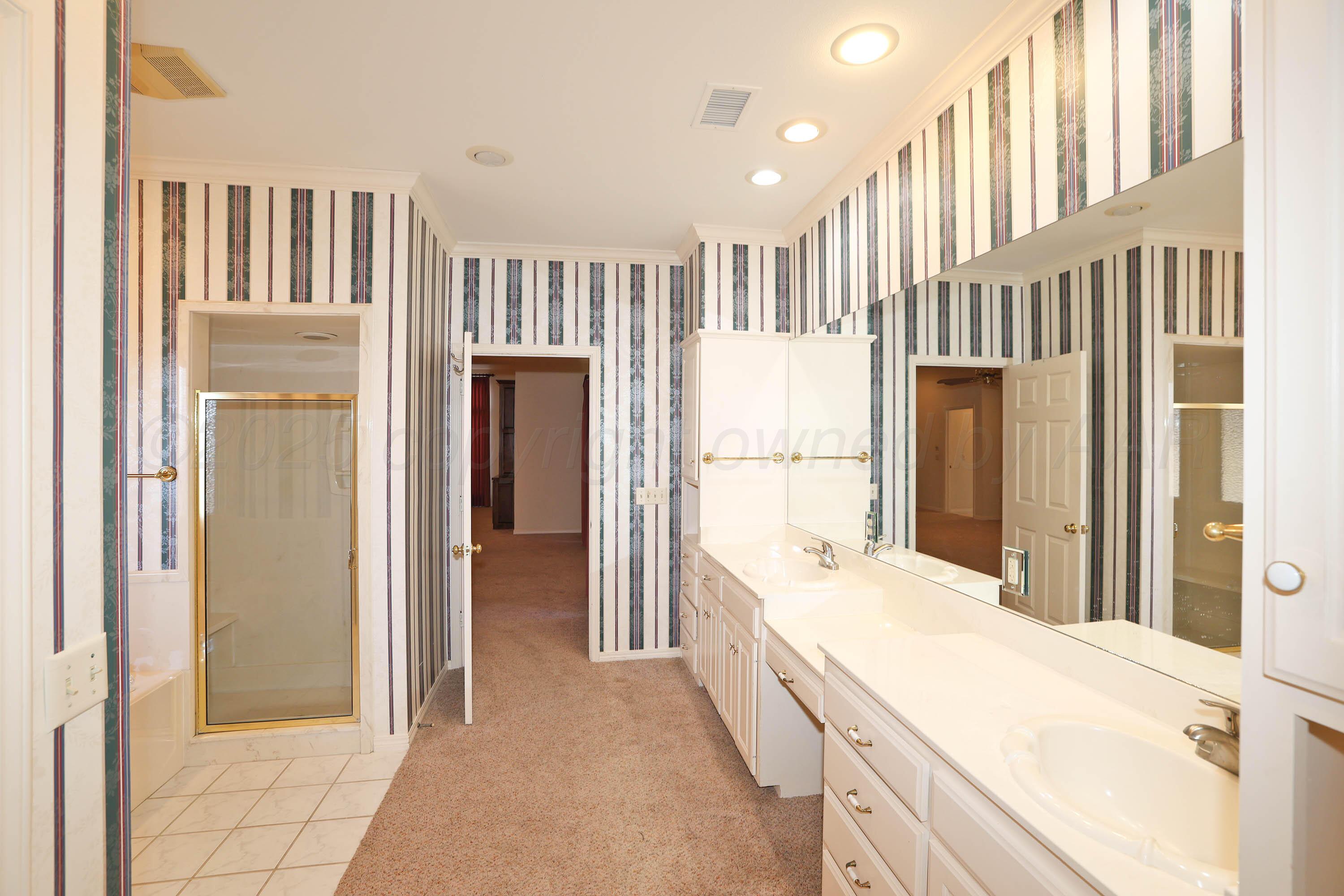7707 Bent Tree Drive Amarillo, TX 79121 - Photo 22 of 47 a bathroom with a double vanity sink and a mirror