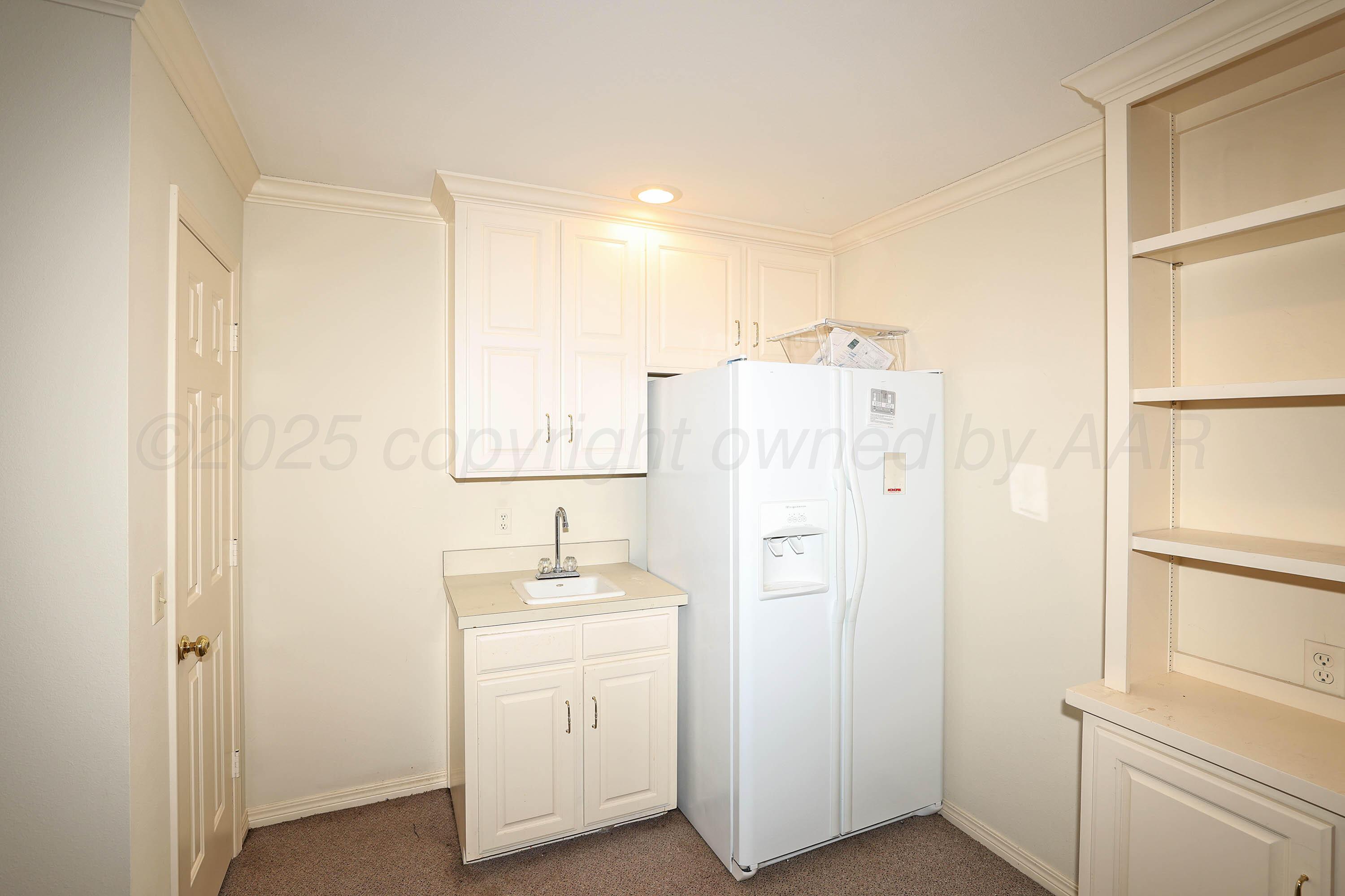 7707 Bent Tree Drive Amarillo, TX 79121 - Photo 42 of 47 a bathroom with a sink a mirror a refrigerator and vanity