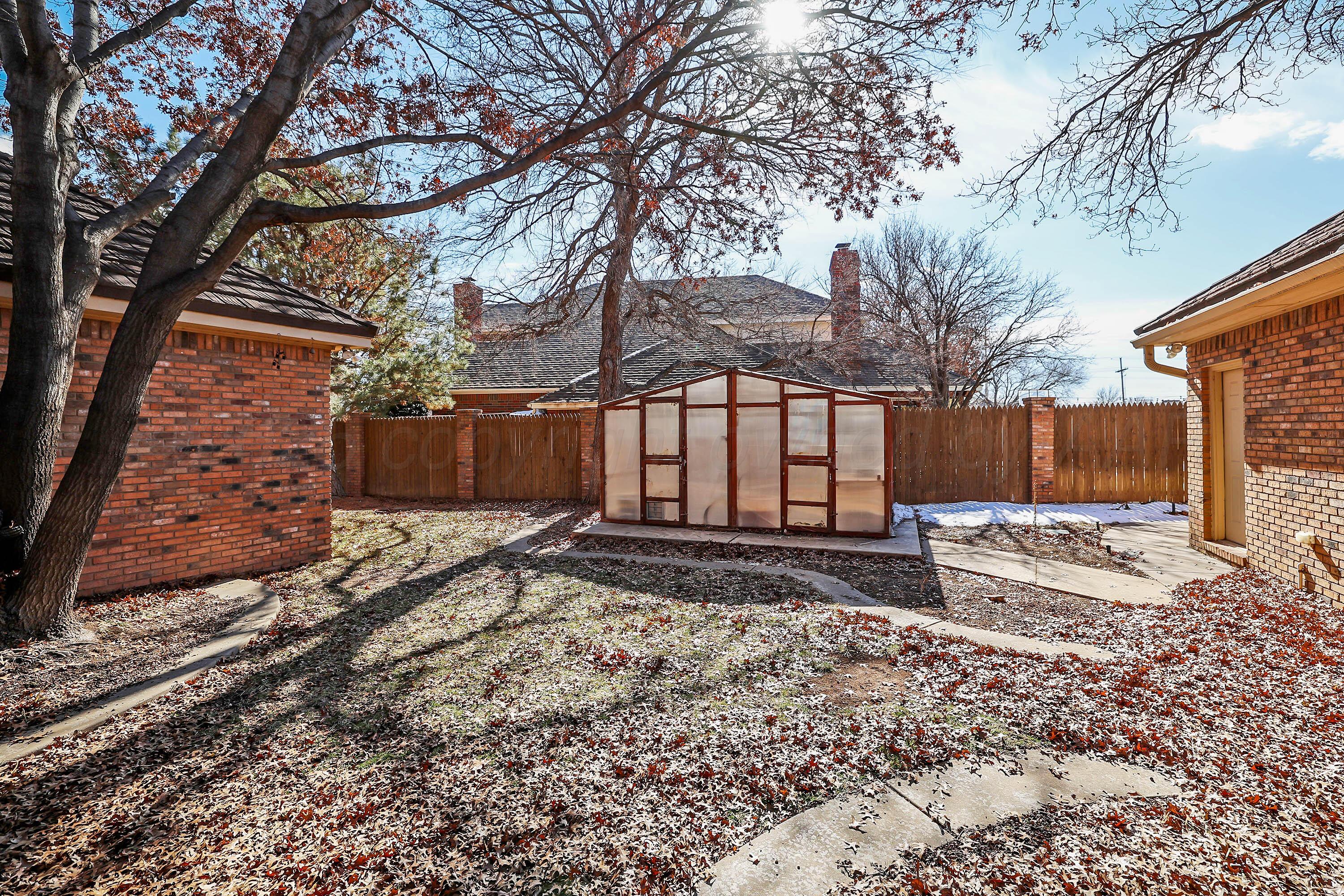 7707 Bent Tree Drive Amarillo, TX 79121 - Photo 44 of 47 a view of a backyard with a tree and wooden fence