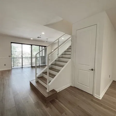 a view of staircase and living room with wooden floor