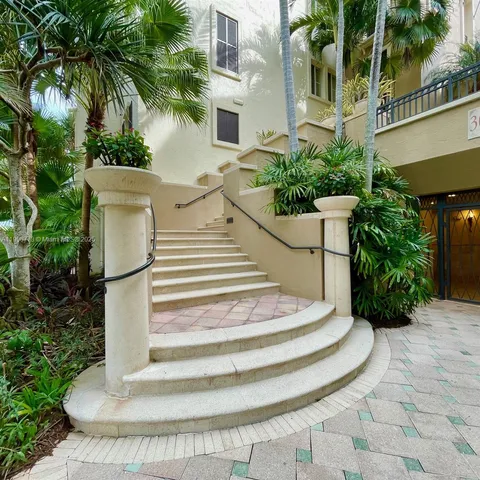 a view of white house with a chair and potted plants