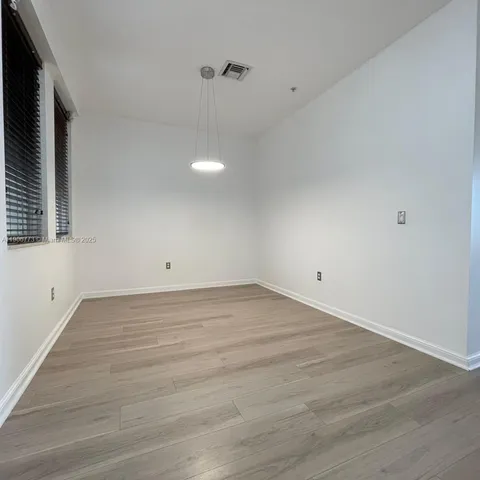 a view of a room with wooden floor and white walls