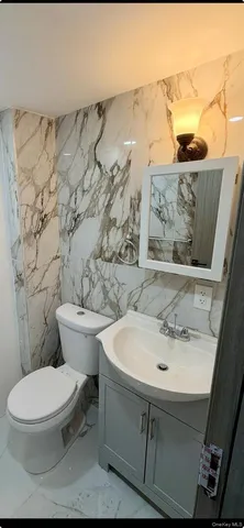 a bathroom with a double vanity sink toilet mirror and bathtub