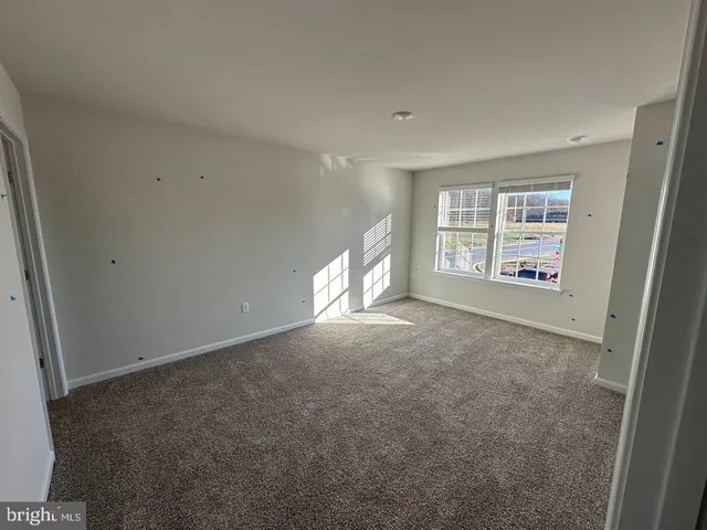 an empty room with a fireplace and windows