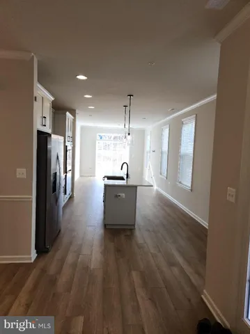 a view of a kitchen with refrigerator and wooden floor