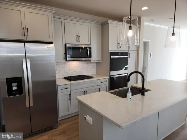 a kitchen with a refrigerator stove and white cabinets
