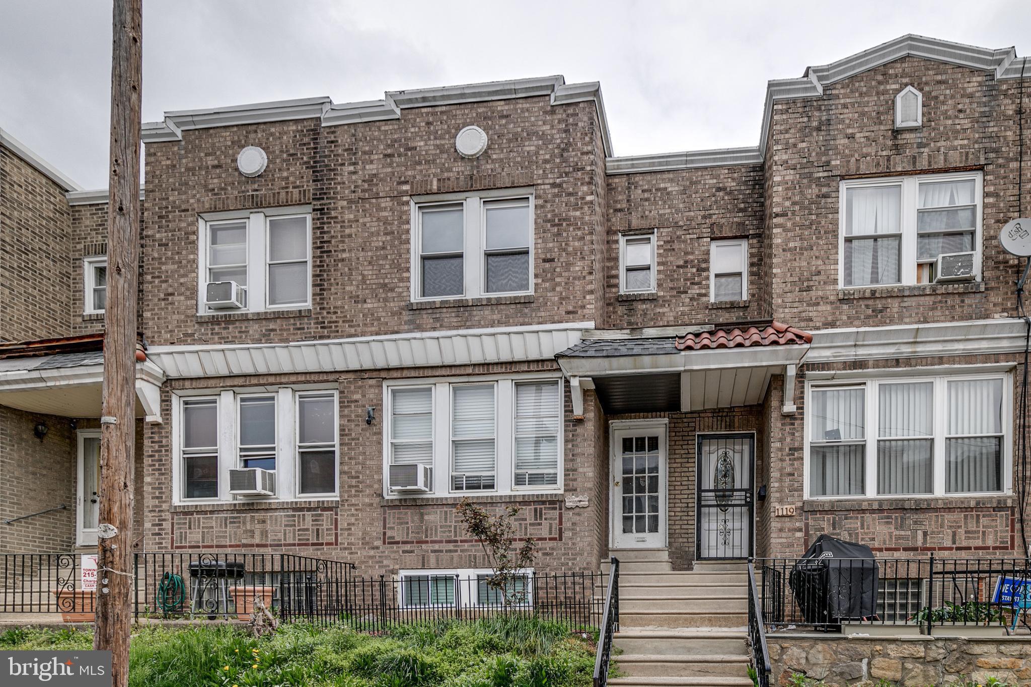 1117 Rosalie Street, Unit 1 Philadelphia, PA 19149 - Photo 1 of 29 a front view of a brick building next to a yard