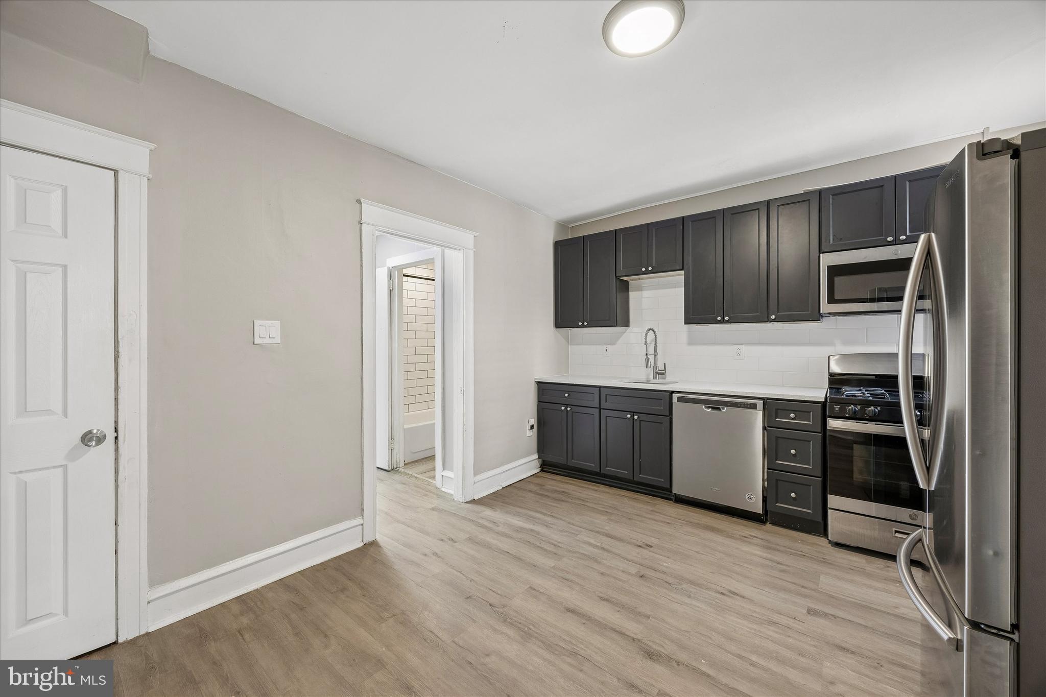 1117 Rosalie Street, Unit 1 Philadelphia, PA 19149 - Photo 12 of 30 a kitchen with stainless steel appliances granite countertop a refrigerator and a stove top oven
