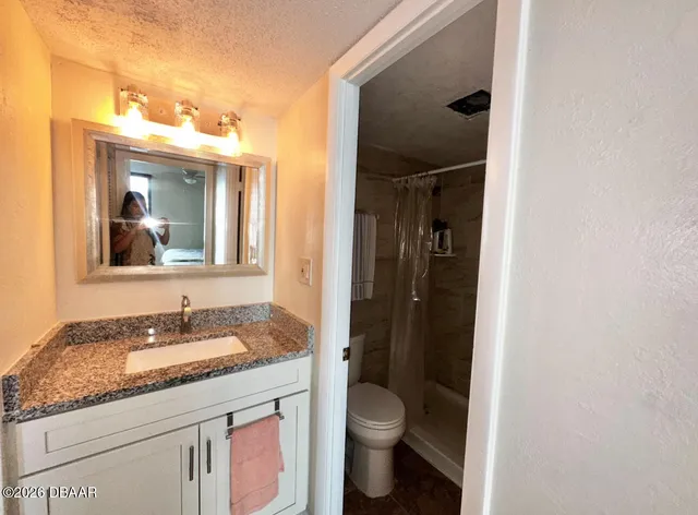 a bathroom with a granite countertop sink toilet and shower