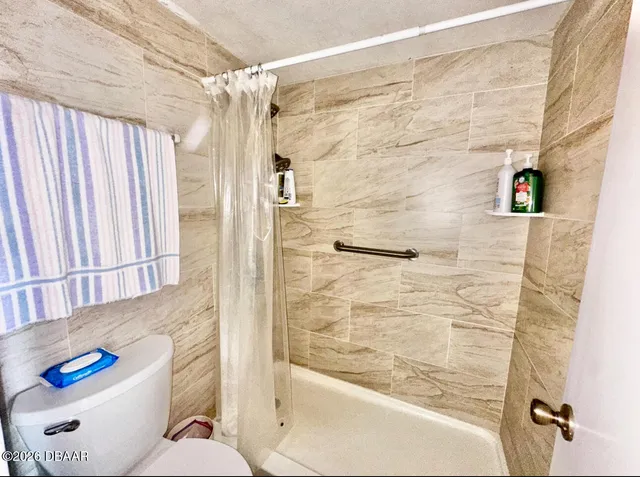 a bathroom with a toilet and a shower