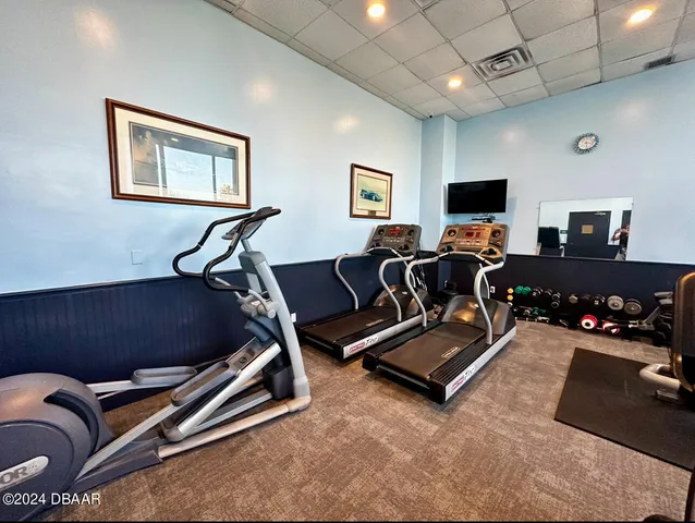 a living room with gym equipment and a flat screen tv