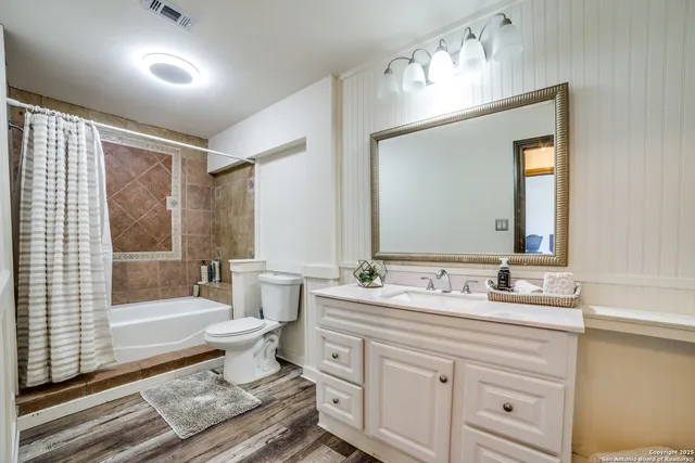 a bathroom with a double vanity sink mirror and bathtub