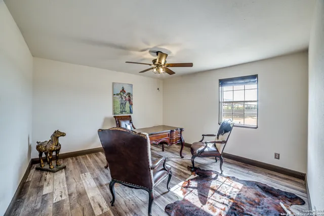 a workspace room with furniture wooden floor and a window