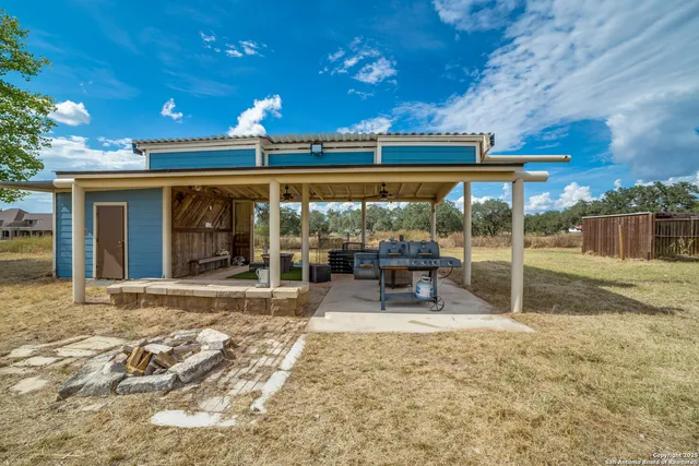 a view of a patio with a table and chairs under a large tree