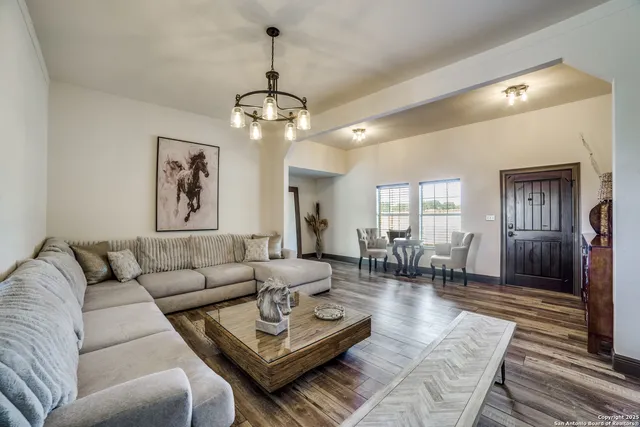 a living room with furniture a chandelier and a table