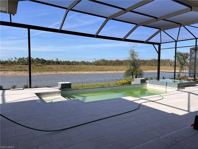 a view of a lake with a table and chairs under an umbrella