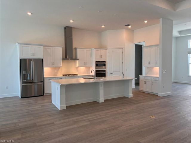 a kitchen with stainless steel appliances a refrigerator and a stove top oven