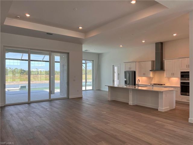 a large kitchen with stainless steel appliances granite countertop a stove and a large window