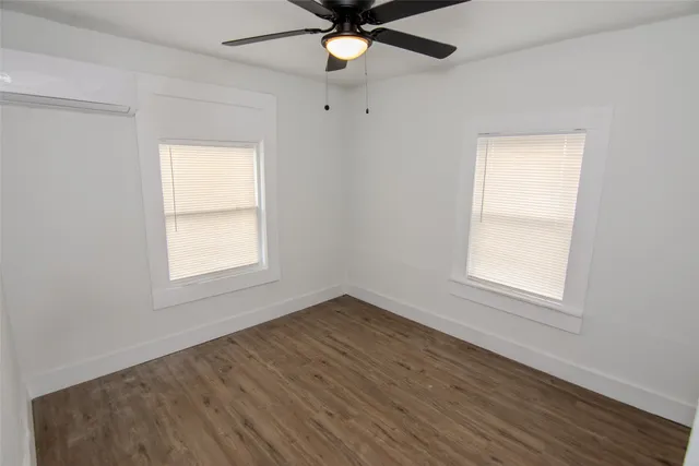 an empty room with window and a ceiling fan