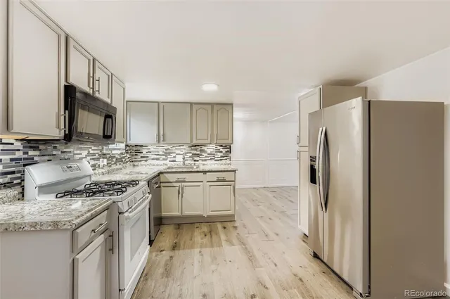 a kitchen with stainless steel appliances granite countertop a refrigerator stove and sink