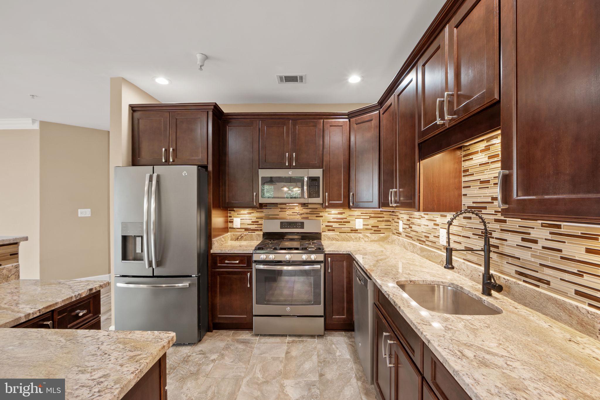 1621 Ladue Court, Unit 105 Woodbridge, VA 22191 - Photo 15 of 60 a kitchen with kitchen island granite countertop a refrigerator stove and sink