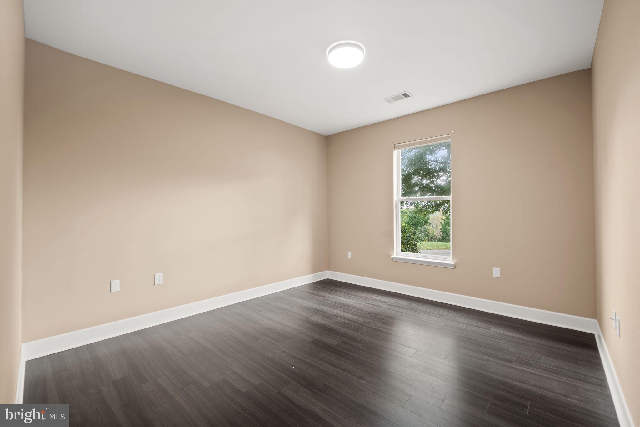 1621 Ladue Court, Unit 105 Woodbridge, VA 22191 - Photo 29 of 60 an empty room with wooden floor and windows