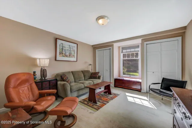 a spacious bedroom with a bed and a dresser with wooden floor