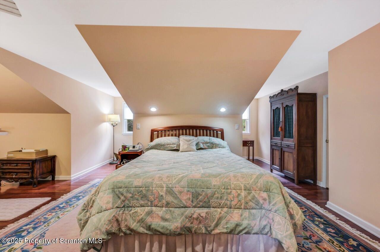 353 Benton Road Dalton, PA 18414 - Photo 40 of 78 a spacious bedroom with a bed and a dresser with wooden floor