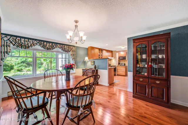 a dining room with furniture a chandelier and wooden floor