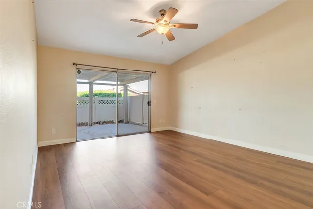 a view of a room with wooden floor and a ceiling fan