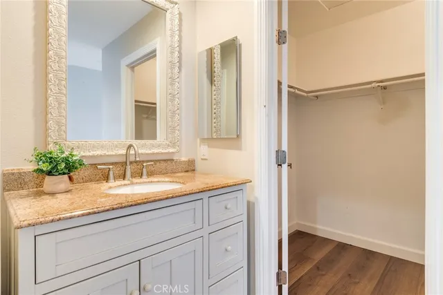a bathroom with a granite countertop sink a mirror and a shower