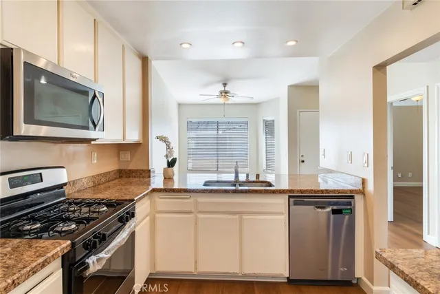 a kitchen with granite countertop a sink stove and cabinets