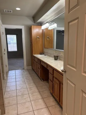 a spacious bathroom with a vanity and a mirror