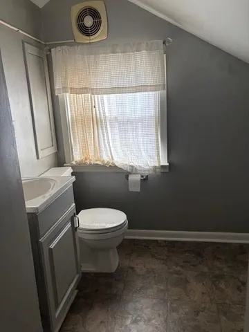 a bathroom with a toilet a sink and a window