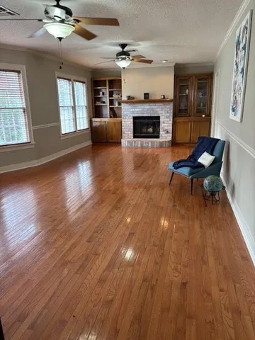 wooden floor fireplace and windows in an empty room