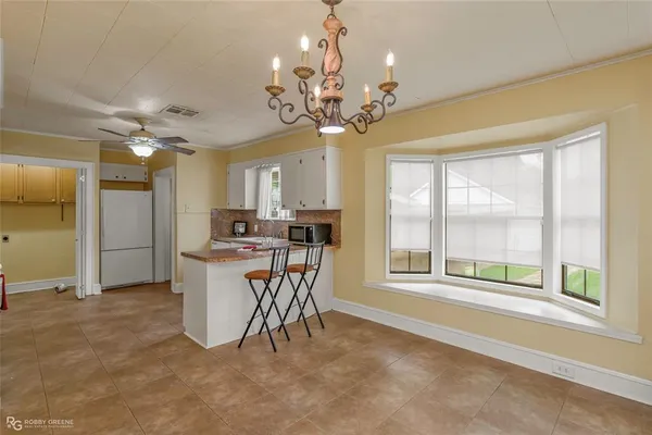 a view of a dining room with furniture a chandelier and a large window