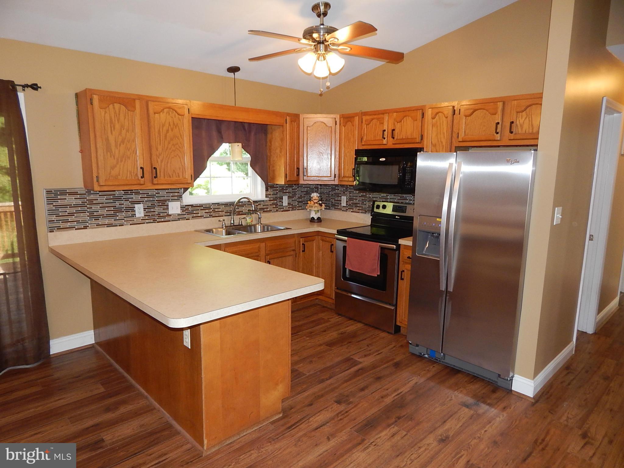 1615 Lottie Fowler Road Prince Frederick, MD 20678 - Photo 4 of 29 a kitchen with stainless steel appliances a stove a refrigerator and a sink